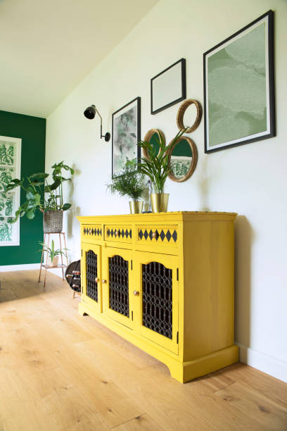 istock Sunny and bright living room with design commode, photo frames and plants. 1030845614
