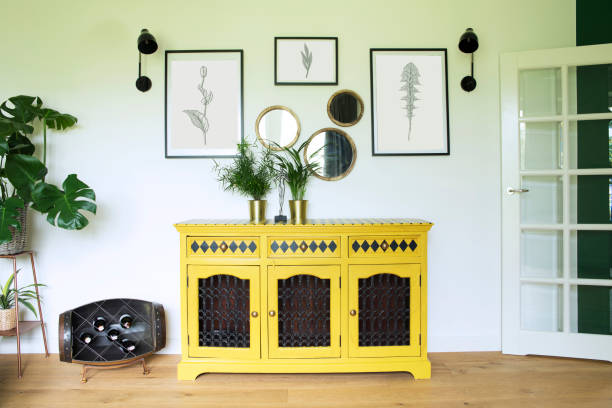 istock Sunny and bright living room with design commode, photo frames and plants. 1030845620
