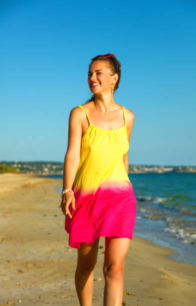 istock smiling active woman on seashore in evening walking 1030847032