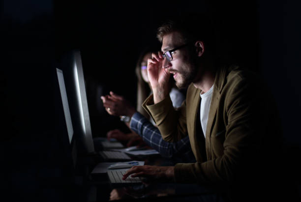 istock tired employees working in the office at night 1030849982