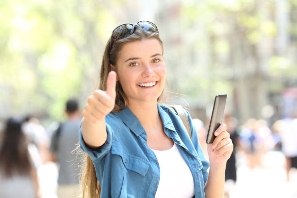 istock Woman smiling holding a smart phone with thumb up 1030850094