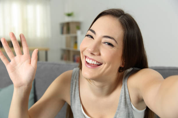 istock Girl waving recording video or taking selfie 1030850272
