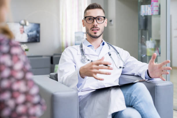 istock Confident young male neurologist in glasses gesturing hands while explaining symptoms to patient, he providing advice on modern brain diseases 1030850418