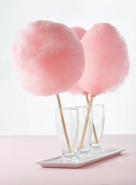 Cotton candy Pink cotton candies on the white background. cotton candy on a stick stock pictures, royalty-free photos & images