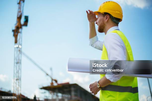 Young Architecte Looking At Works On Construction Site Stock Photo - Download Image Now