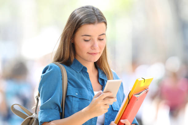 istock Relaxed student using a phone in the street 1030854390