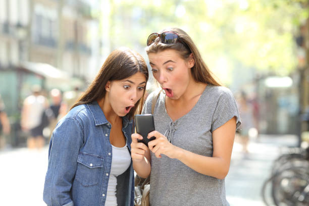istock Surprised friends finding online content in a phone 1030854456