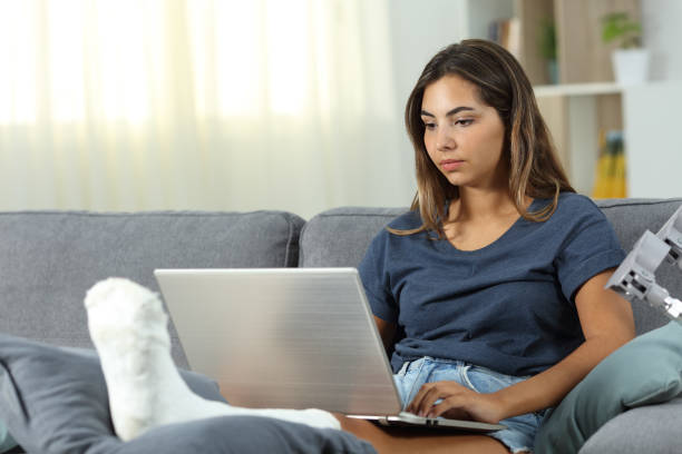 istock Serious desabled woman using a laptop at home 1030856814