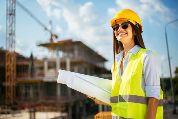 istock Young female architect with blueprint on construction site 1030860946
