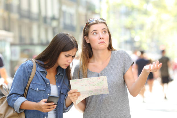 istock Lost tourists consulting map and phone 1030865132