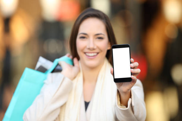 istock Shopper showing a blank phone screen mock up outdoors 1030865484