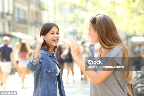 Friends Meeting And Greeting In The Street Stock Photo - Download Image Now - Greeting, Waving - Gesture, Friendship
