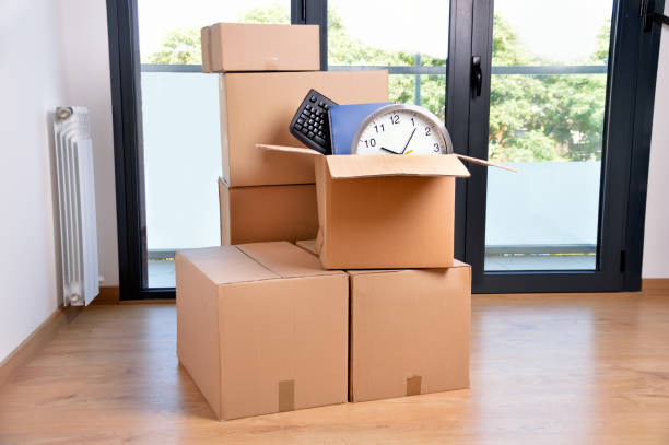 boxes with accessories Office accessories in a cardboard box at office. Downsizing stock pictures, royalty-free photos & images