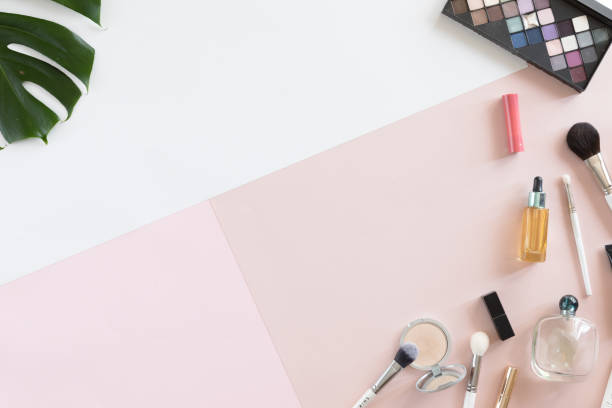 istock Flat lay and top view of female office table desk. Workspace with make-up set, palm leaves on pastel pink and white background.. 1030866310