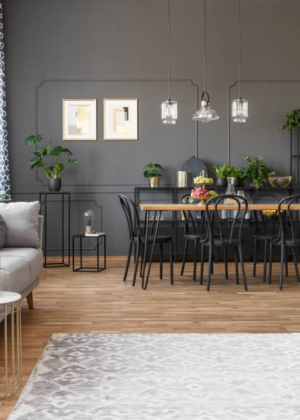 istock Grey carpet in apartment interior with black chairs at dining table and posters on the wall. Real photo 1030868728