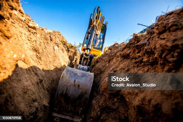 Excavator Digs The Foundation For The House Stock Photo - Download Image Now - Backhoe, Digging, Compact Excavator