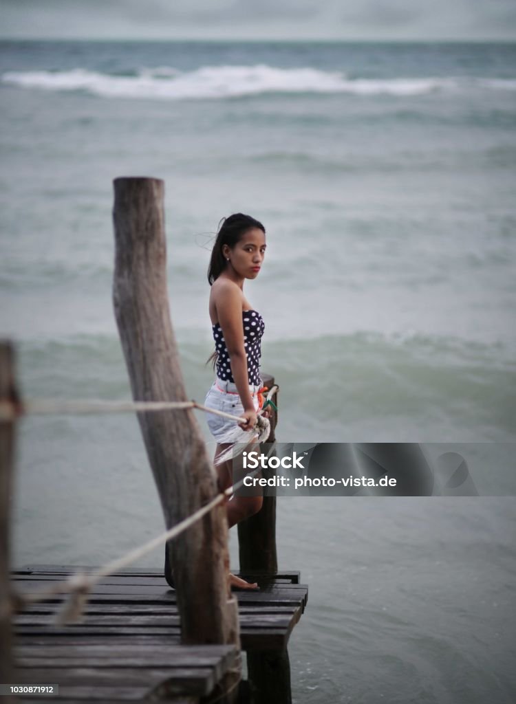 Girl on a catwalk in stormy weather Girl on a wooden catwalk in stormy weather thinking looking Adult Stock Photo