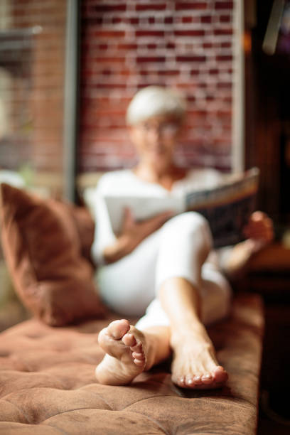 Portrait of active senior woman with eyeglasses in coffee shop while reading a magazine.