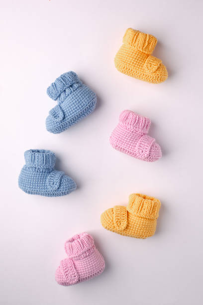 istock pregnancy concept, Three pairs of baby booties on a light background, flat lay, pattern 1030877954