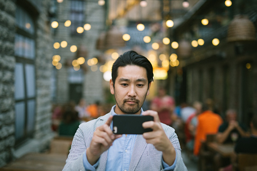 Portrait of businessman taking photos with his smartphone. There's room for copy space.