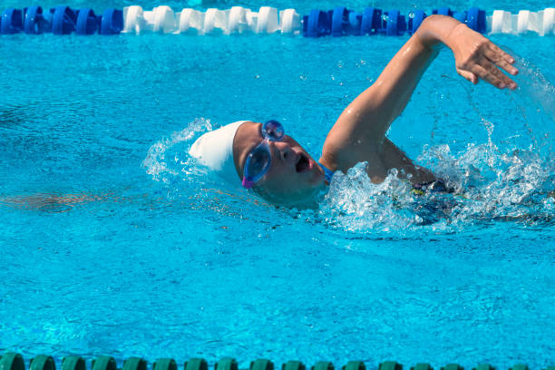 side wiev of 13 years old teenager swimming freestyle outdoors - 12 13 years fotos imagens e fotografias de stock