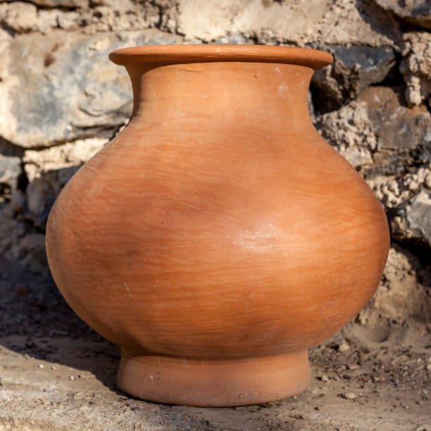 istock Single traditional Clay Pot with brick wall at background in Myanmar. 1030886822