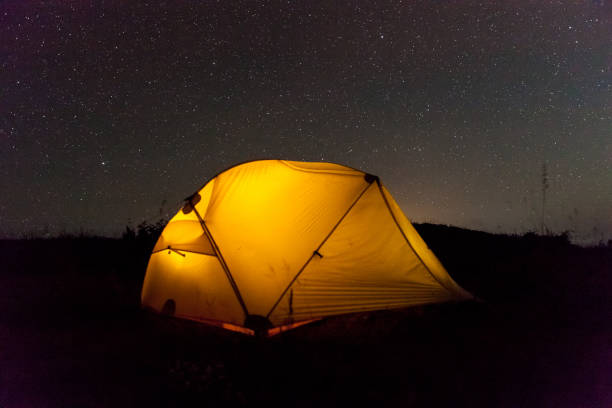 istock Yellow illuminated tent under night sky. 1030887054