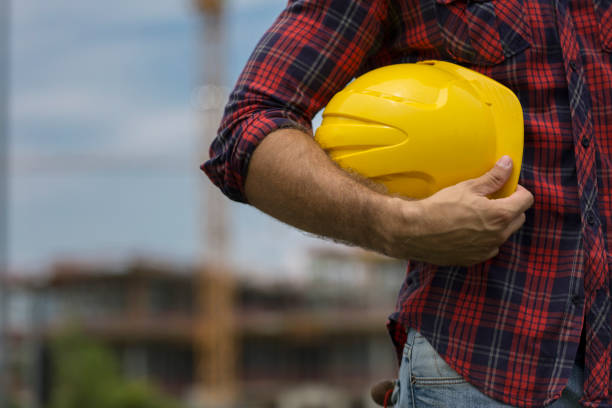 istock Close-up of architect holding blueprints and hardhat 1030887118