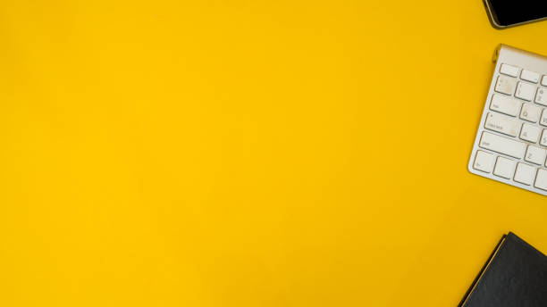 istock workspace desk with keyboard and smartphone copy space background yellow 1030894014