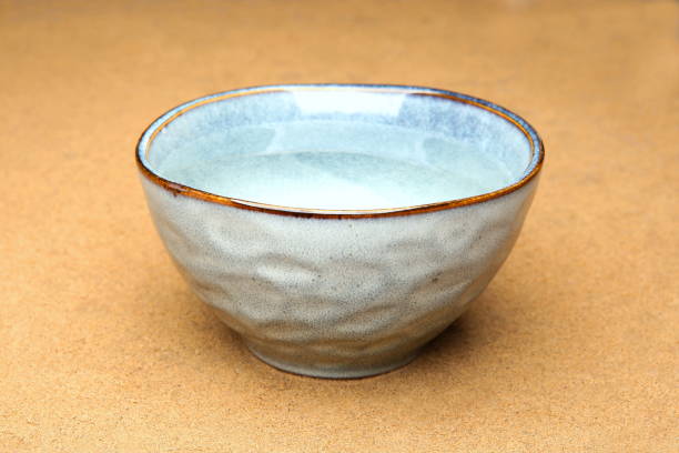 istock Blue ceramic  bowl with clean drink water on sand. 1030896602