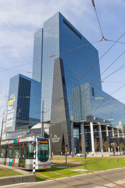 tram passing modern buildings of Rotteram Rotterdam, the Netherlands - April 7 2018; modern tall buildings in centre of the city with RET tram in foreground tasrail stock pictures, royalty-free photos & images