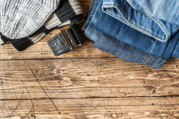 istock Jeans clothes and accessories on brown wood background 1030903924