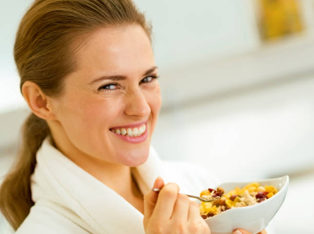 istock happy young woman in bathrobe eating healthy breakfa 1030907800