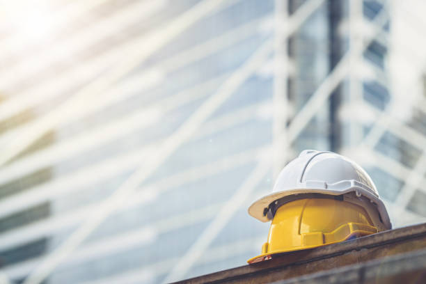 istock Low Angle View Of Hardhats On Table Against Building 1030907988