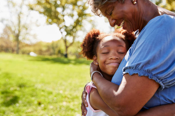公園で祖母を抱き締める孫娘のクローズ アップ - family grandmother child happiness ストックフォトと画像