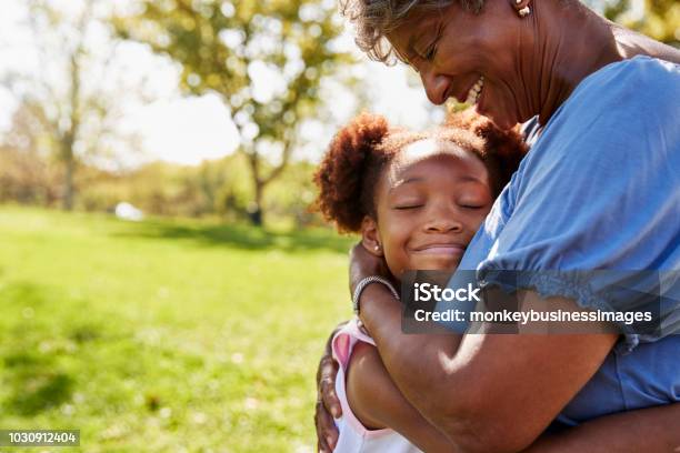Foto de Closeup Da Neta Abraçando A Avó No Parque e mais fotos de stock de Avó - Avó, Família, Criança