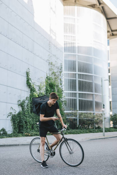 istock Bicycle messenger checking directions on smartphone 1030912672