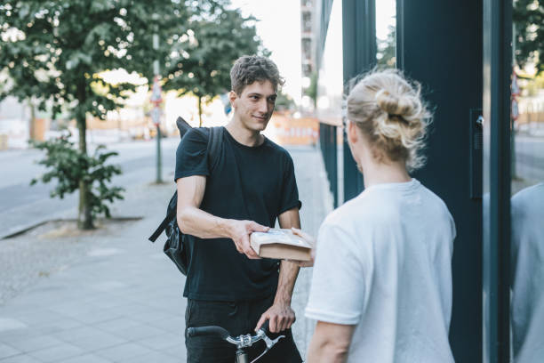 bike courier delivering a package to client - bicycle messenger imagens e fotografias de stock