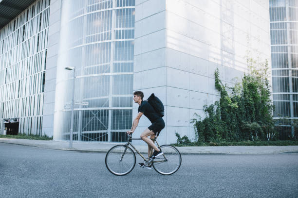 bike messenger riding down the street. - candid people casual bicycle imagens e fotografias de stock