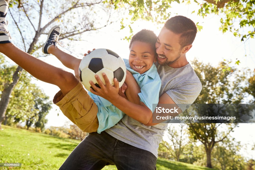 Vater und Sohn zusammen spielen Fußball im Park - Lizenzfrei Familie Stock-Foto