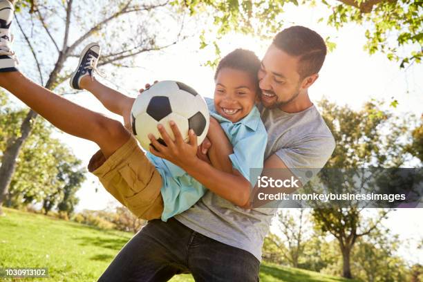 Padre E Figlio Giocano A Calcio A Park Insieme - Fotografie stock e altre immagini di Famiglia - Famiglia, Padre, Calcio - Sport