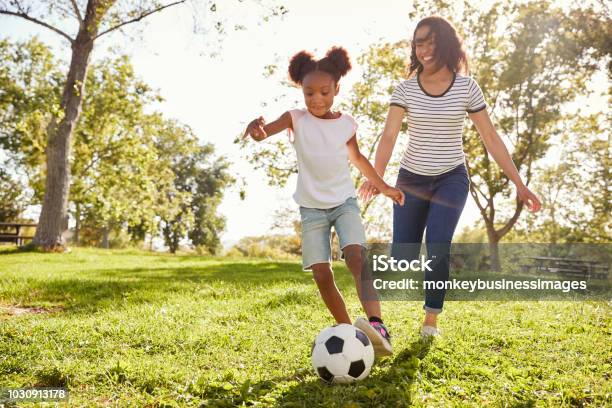 Mother And Daughter Playing Soccer In Park Together Stock Photo - Download Image Now