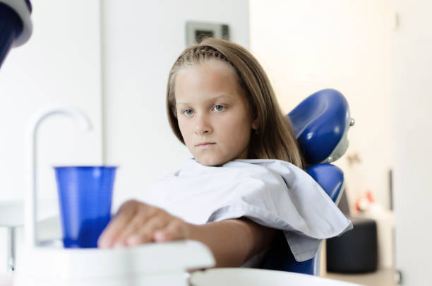 istock girl holding plastic cup at dentist 1030913336