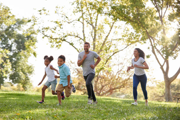 istock Family Running Through Park Together 1030913418