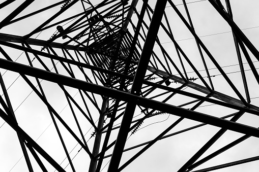 Under overhead high-voltage power line tower. View from bottom of construction