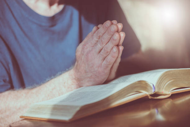 istock Man praying with his hands over the bible 1030916946