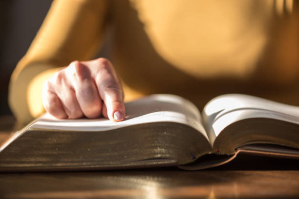 istock Woman reading the bible, hard light 1030917256