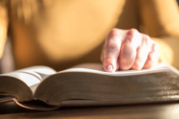 istock Woman reading the bible, hard light 1030917286