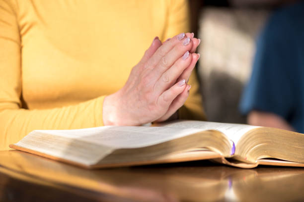 istock Woman praying with her hands over the bible 1030921064