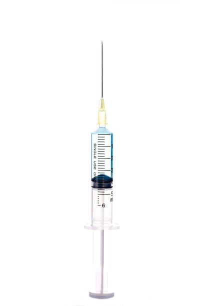 istock Syringe closeup with blue serum isolated on white background. 1030922394